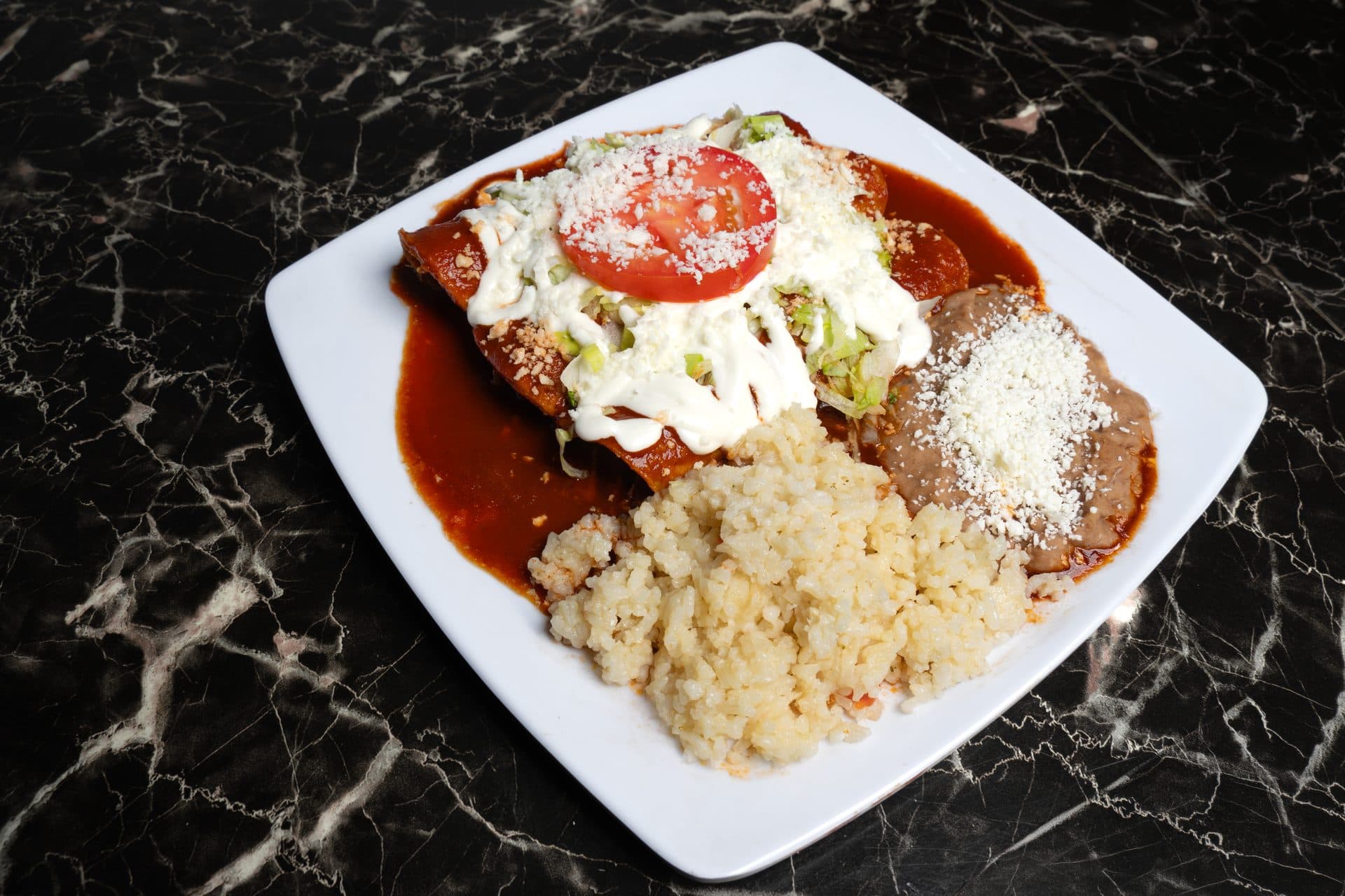 Enchiladas con crema, arroz y frijoles