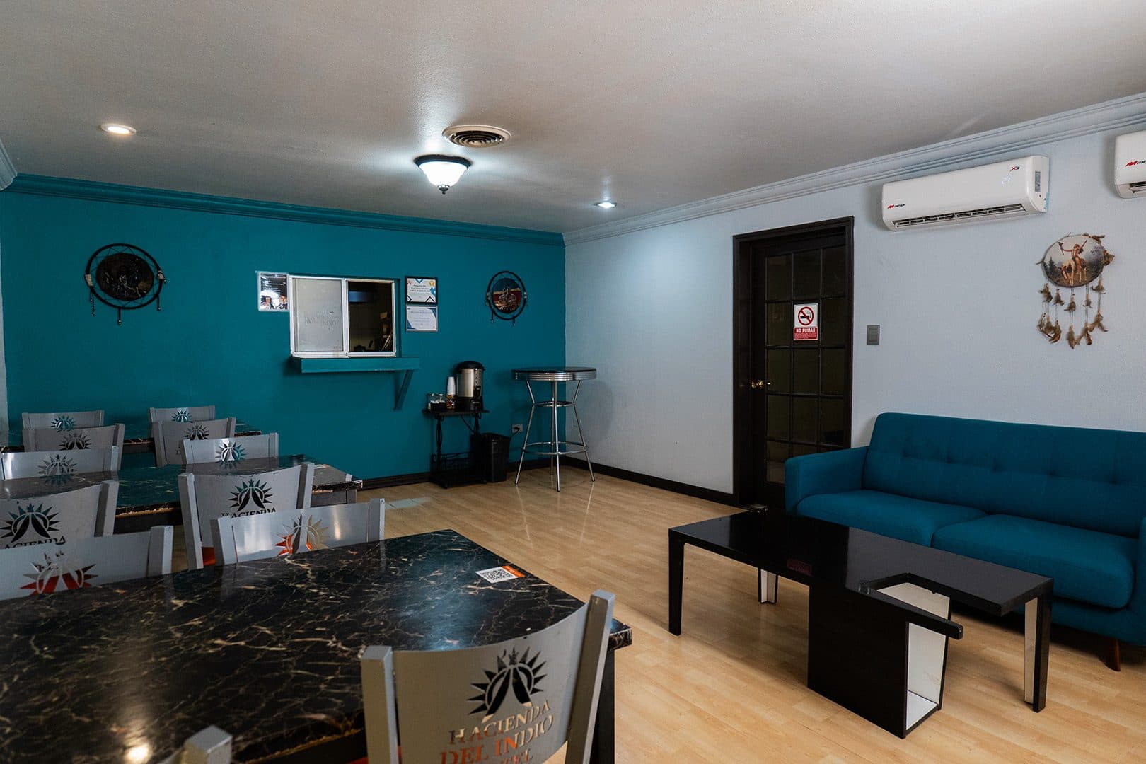 Comedor con mesas de mármol y sala con sillones turquesa