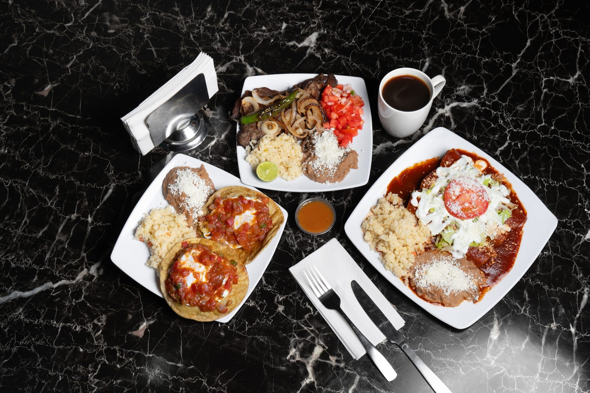 Mesa con varios platillos mexicanos, café y cubiertos